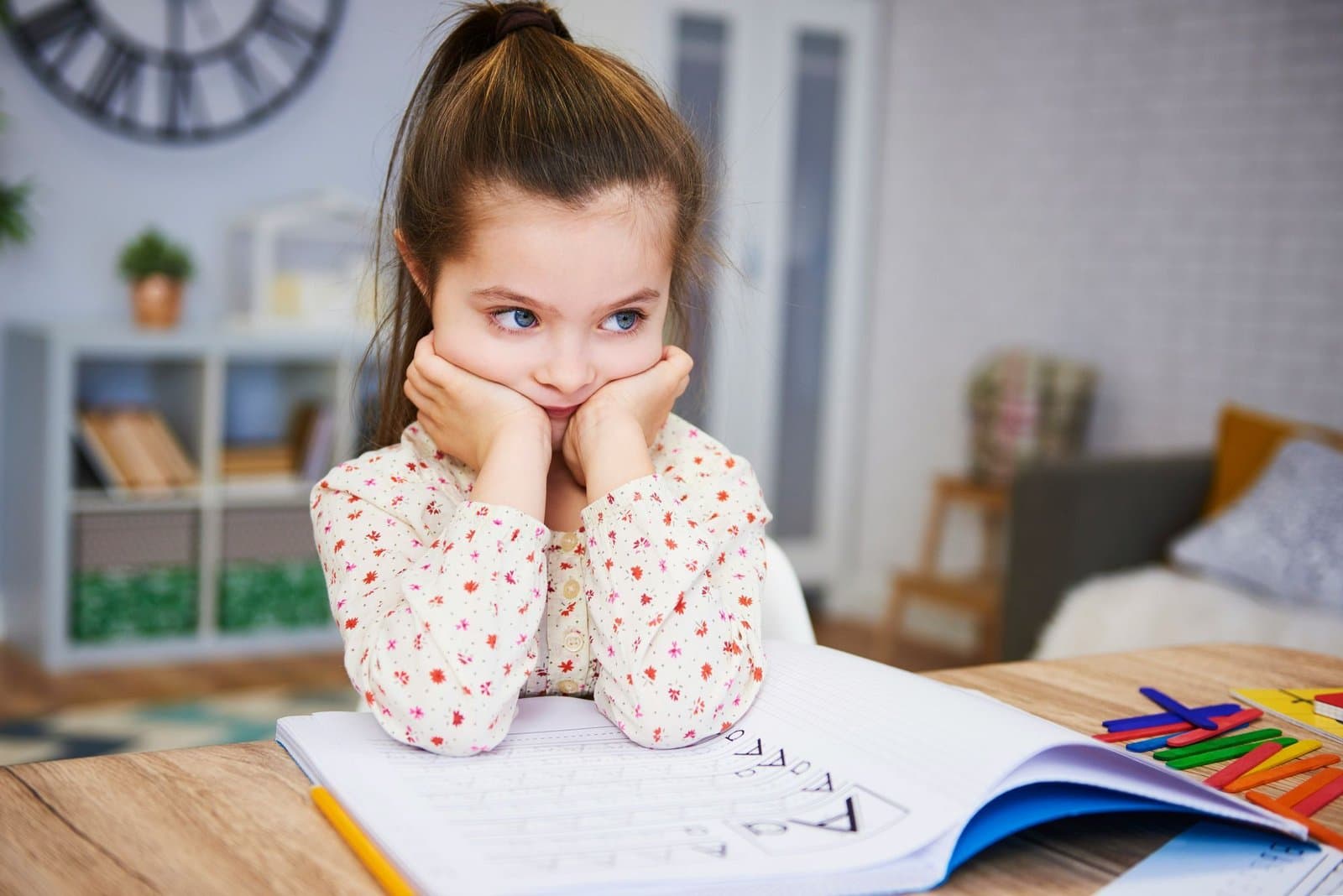A foto retrata uma menininha em momento de estudo ou tarefa escolar.